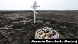 Jucării de pluș lângă o cruce ridicată în memoria victimelor prăbușirii zborului Malaysia Airlines MH17 în satul Rojîpne din regiunea Donețk, Ucraina. 