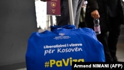 Un pasager cu pașaport kosovar și bagaj pe care scrie „Fără Viză”, la Aeroportul Internațional Pristina, pe 1 ianuarie 2024, ziua liberalizării regimului european de vize pentru Kosovo.