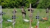 Ресей әскери қызметкерлерін жерлеу рәсімінде зиратты күзетіп тұрған сарбаз. Луганск, Украинаның Ресей бақылауындағы бөлігі. 18 мамыр, 2023 жыл.