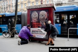 Katalin Cseh (desno) iz opozicione stranke Momentum pomaže u postavljanju plakata na kojem piše: "Svako šesto mađarsko dijete je rođeno u inostranstvu. Nemojmo predati svoju budućnost", u Budimpešti u februaru 2019.