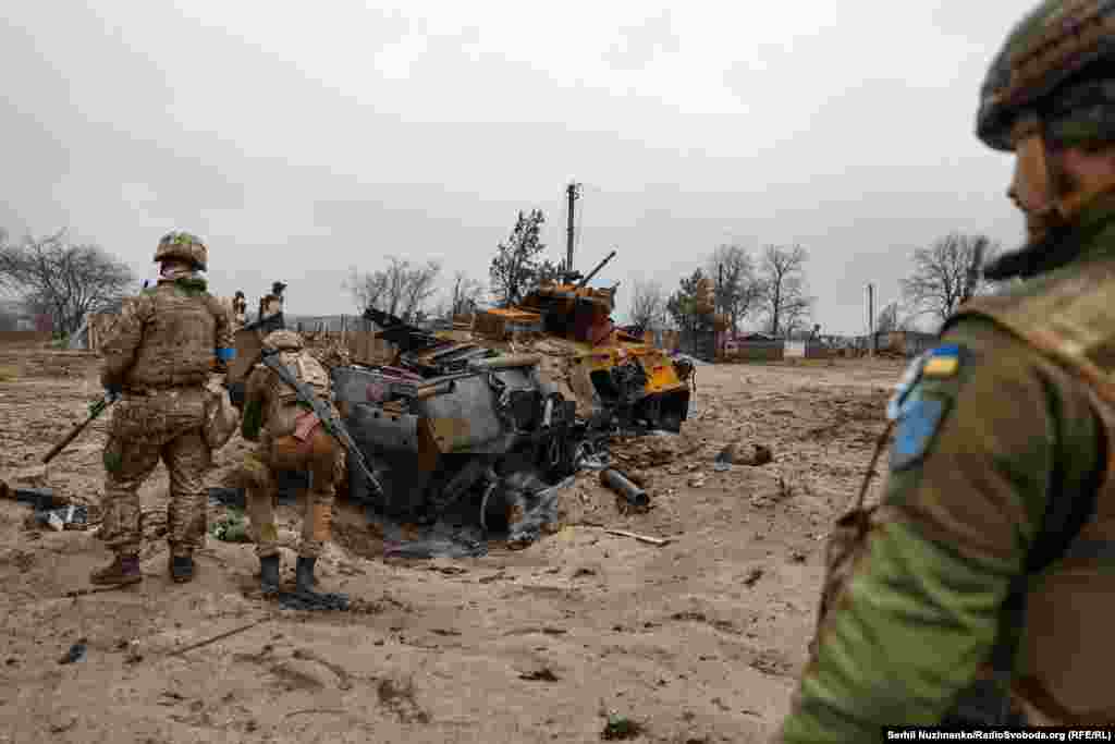 Imaginea 1: Soldații ucraineni inspectează un transportor blindat rusesc distrus în Teterivske. Imaginea 2: În afară de un crater, locul unde echipamente militare rusești au ars în 2022 nu mai păstrează aproape nici o urmă a luptei.&nbsp;