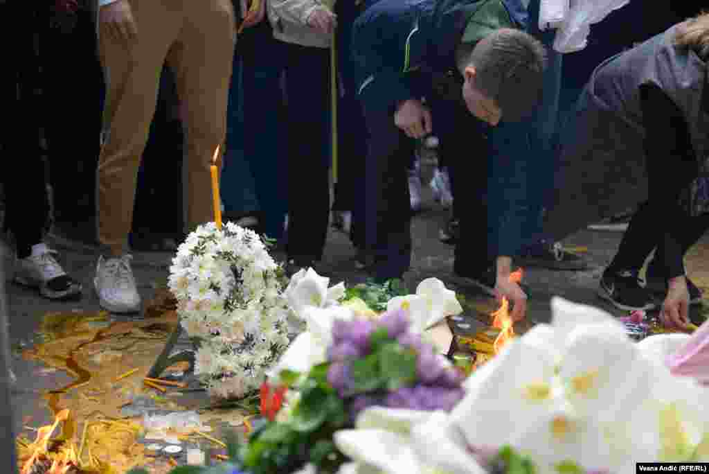 U kolonama čekaju da zapale sveće ispred škole u kojoj se dan ranije dogodila tragedija. 