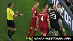 Golman Srbije Vanja Milinković-Savić drži švajcarskog fudbalera Granita Džaku za vrat tokom fudbalske utakmice između Srbije i Švajcarske 2. decembra 2022. 