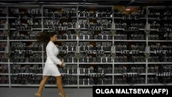 O femeie trece prin fața unor unități de procesare folosite în extragerea bitcoinului și a altor monede virtuale de la Kriptoyunivers, cel mai mare centru al criptomonedelor din Rusia, 20 august 2018.