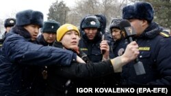 Корреспондент "Азаттыка" в окружении сотрудников милиции во время освещения акции протеста в Бишкеке. Январь 2023 года. 