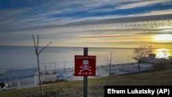 Знак „Опасност! Мини!“ на градска плажа на брегот на Црното море во Украина, 14 ноември 2022 г.