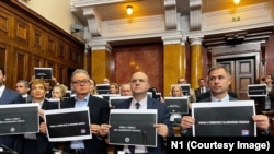Pojedini opozicioni poslanici u Skupštini Srbije drže natpis "Mrak u Srbiji bez slobodnih medija" u znak podrške televizijama N1 i Nova S koje su 6. decembra prekinule emitovanje.
