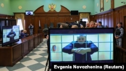 Ruski opozicioni lider Aleksej Navaljni se vidi na ekranima putem video linka iz popravne kaznene kolonije IK-2 u Pokrovu tokom sudskog saslušanja za razmatranje žalbe na njegovu zatvorsku kaznu u Moskvi 24. maja 2022.