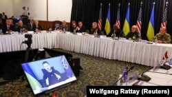 Президент України Володимир Зеленський (на екрані) під час виступу через відеозв’язок на черговій зустрічі у форматі «Рамштайн». Авіабаза Рамштайн, 20 січня 2023 року