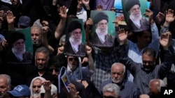 Credincioșii iranieni scandează sloganuri în timp ce țin în mâini postere cu liderul suprem Ayatollah Ali Khamenei, în cadrul unei manifestații anti-SUA și anti-Israel. 25 iulie 2025.