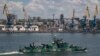  O navă a Marinei Ruse trece pe lângă portul maritim de marfă Mariupol, un oraș ucrainean ocupat de pe Marea Azov, în iunie 2022.