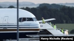 Članovi posade se ukrcavaju u avion za koji su britanski mediji javili da je prvi kojim je trebalo da budu prevezeni migranti u Ruandu, baza u Wiltshireu, Velika Britanija, 14. juna 2022.