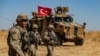 Американские военные проходят мимо турецкой техники