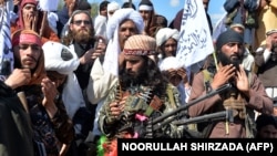 FILE: Afghan Taliban militants and villagers attend a gathering as they celebrate the peace U.S. in Alingar, a district of the eastern Laghman Province in March