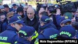 შსს-ის ცნობით, მელია „პოლიციელის შეურაცხყოფისთვის“ დააკავეს. ნიკა მელია პოლიციელების გარემოცვაში. ფოტო არქივიდან. 