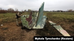 Український військовий оглядає останки російського бойового літака Су-25, архівне фото 