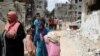 Palestinci pored srušenih kuća u Beit Hanounu u sjevernom pojasu Gaze, 21. maja 2021. 