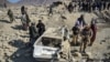 Personalul de securitate taliban inspectează o mașină avariată la două zile după loviturile aeriene ale Pakistanului în districtul Barmal din estul provinciei Paktika, în decembrie. 
