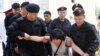 Kazakh police officers detain an opposition supporter attempting to stage a protest rally in Almaty on June 23. 