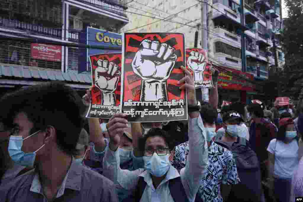 Protestatarii dețin semne de denunțare a armatei în timpul unei demonstrații împotriva loviturii de stat din Yangon 