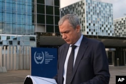 Prognani bjeloruski opozicioni aktivista Pavel Latuška čita iz dosijea nakon što je predočio dokaze ICC-u o ličnoj umiješanosti Aleksandra Lukašenka u ilegalnom prebacivanju djece u Bjelorusiju iz dijelova Ukrajine pod ruskom okupacijom, u Hagu 7. novembra 2023.