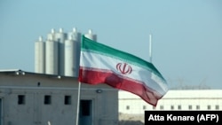 د ایران بوشهر اټومي بټۍ ودانۍ مخې ته د هغه هېواد بیرغ رپېږي - پخوانی انځور. 
