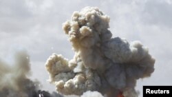 Ливия -- Каддафинин күчтөрүнө тиешелүү аскер техникалары Бенгазинин жанындагы жолдо коалициялык күчтөрдүн аба соккусунан улам жарылууга дуушар болду, 20-март.