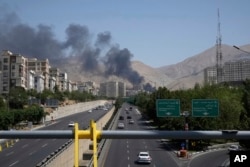 În imagine, fum care se ridică dintr-o instalație de depozitare a petrolului după ce aceasta pare să fi fost lovită într-un atac israelian sâmbătă, 14 iunie, la Teheran.