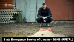 Un bărbat privește cadavrul unei femei ucise în timpul unui atac al unei drone rusești în regiunea Kiev pe 18 mai.