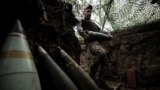 Військовослужбовець 24-ї ОМБр ЗСУ імені короля Данила несе снаряд для самохідної гаубиці M109 на позиції поблизу Часового Яру, Донецька область, 14 червня 2025 року