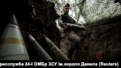 Військовослужбовець 24-ї ОМБр ЗСУ імені короля Данила несе снаряд для самохідної гаубиці M109 на позиції поблизу Часового Яру, Донецька область, 14 червня 2025 року