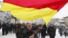Georgia -- A supporter of South Ossetian Presidential candidate Alla Dzhioyeva waves the national flag during a meeting in Tskhinvali, 29Nov2011
