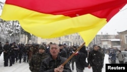 Georgia -- A supporter of South Ossetian Presidential candidate Alla Dzhioyeva waves the national flag during a meeting in Tskhinvali, 29Nov2011