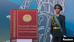 Военнослужащий рядом с макетом Конституции в День Конституции. Алматы, 30 августа 2014 года.