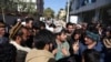 Afghan visa seekers stand outside the Pakistani Embassy in Kabul on November 4 after consular services were halted amid the row.