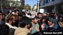 Afghan visa seekers stand outside the Pakistani Embassy in Kabul on November 4 after consular services were halted amid the row.