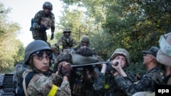 Українські військові несуть пораненого під час бою проти бойовиків поблизу міста Іловайськ, 10 серпня 2014 року 