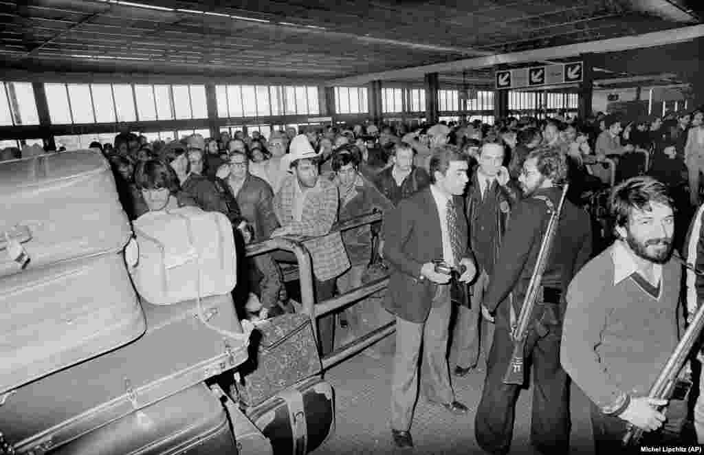 Naoružani muškarci, pristalice ajatolaha Homeinija, drže stražu na teheranskom aerodromu Mehrabad, 18. februara, 1979. godine. Stotine američkih državljana pokušale su da se ukrcaju na let za evakuaciju i tako napuste Iran.