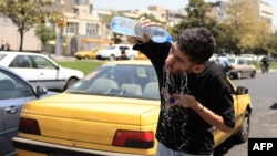 Un șofer de taxi iranian se răcorește în căldura extremă de la Teheran, iulie 2025. 