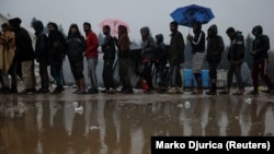 Migranti u redu za hranu u kampu Vučjak