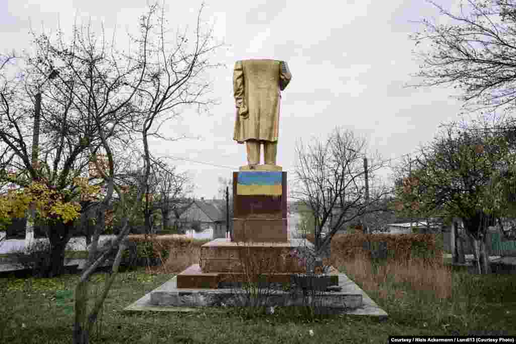 Obezglavljena statua Lenjinu ofarbana sprejom u bojana ukrajinske zastave, Shabo.