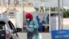 A health worker wearing a protective face mask takes someone's medical history at the drive-through screening and testing facility for coronavirus in Karachi on April 7. 