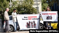 Участники пикета встречали гостей форума плакатами