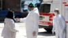 Medicinski radnik mjeri temperaturu jednoj ženi prije nego joj se dozvoli pristup bolnici, Sarajevo, 9. april